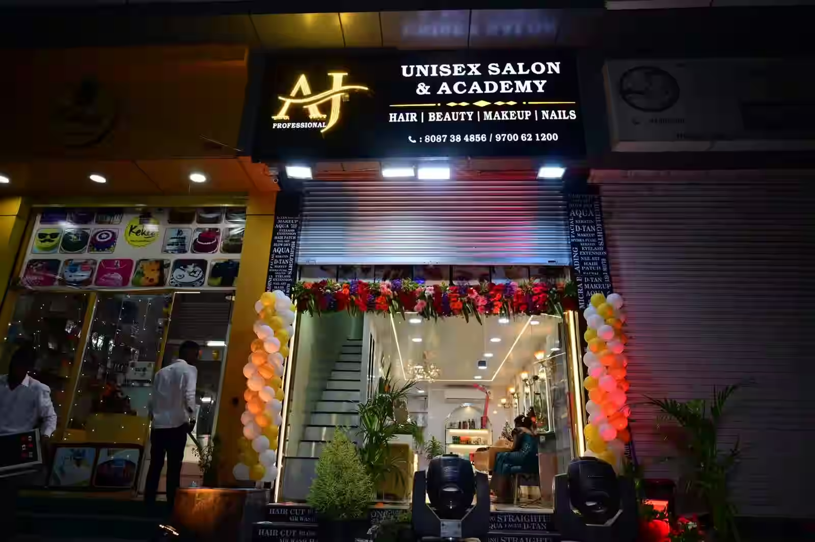 AJ Professional Unisex Salon entrance lit up at night
